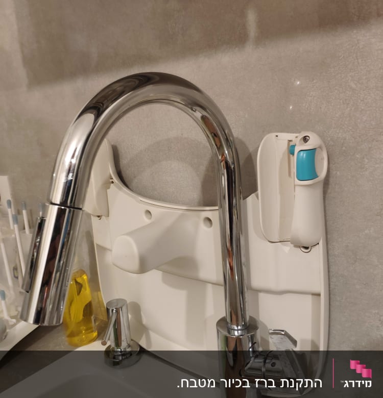ברז נירוסטה עם ידית סבון ליד כיור